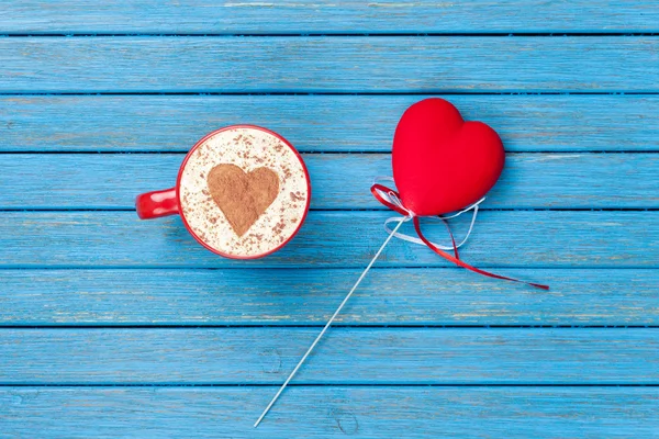 Cup of Cappuccino with heart shape symbol and toy