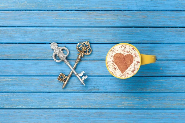 Cup of Cappuccino with heart shape symbol and two keys
