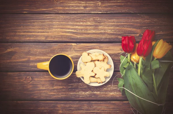 Cup of coffee and tulips with cookies