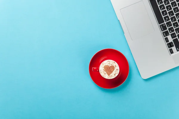 Cappuccino with heart shape and laptop