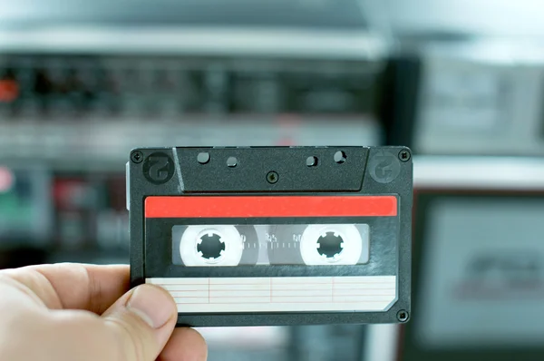 Plastic cassette audio tape in a man's hand