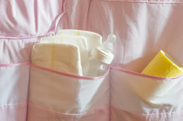 Baby diapers, wipes, and feeding bottle in the pocket