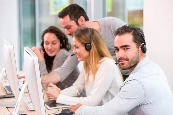 Young attractive people learning their new job at call center