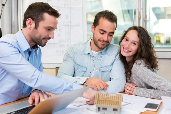 Young attractive people meeting real estate agent at the office