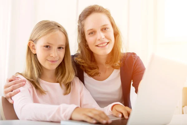 Woman helping out her little sister for homework
