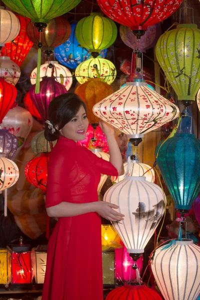 Girl in national clothes sell chinese lanterns in a souvenir shop. Hoi An, Vietnam