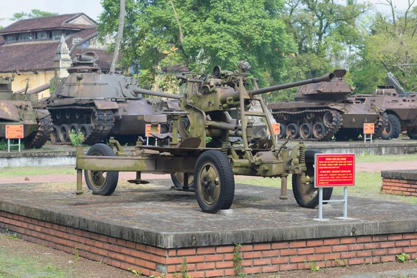 37-mm anti-aircraft gun in the background of American armored vehicles of the period of the Vietnam war in Hue, Vietnam
