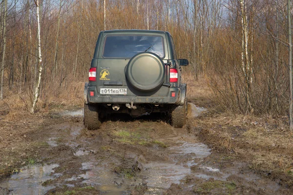 UAZ-Patriot stuck on the road in the mud in the spring woods