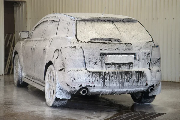 The car is covered with the active foam at the car wash