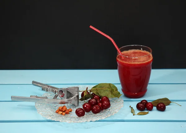 Still life with cherries, fresh juice, seeds and extractor