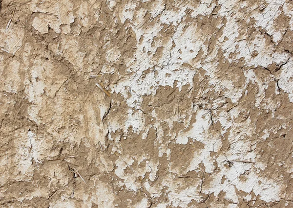 Texture of grey adobe wall with pieces of straw