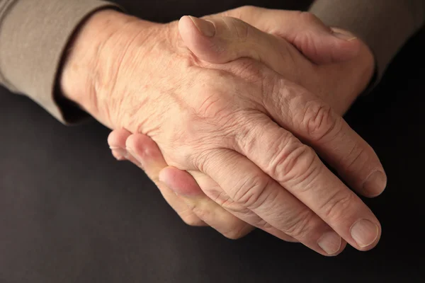 Older man holding his numb hand  