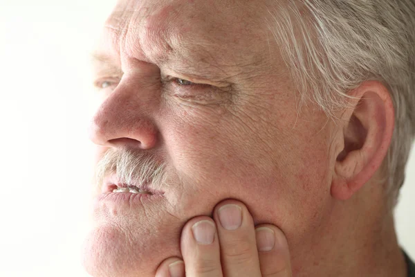 Senior man has jaw or tooth pain