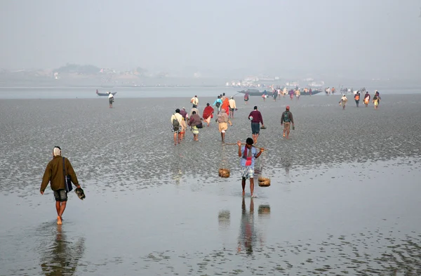 During low tide the water in the river Malta falls so low that people walk to the other shore in Canning Town, India