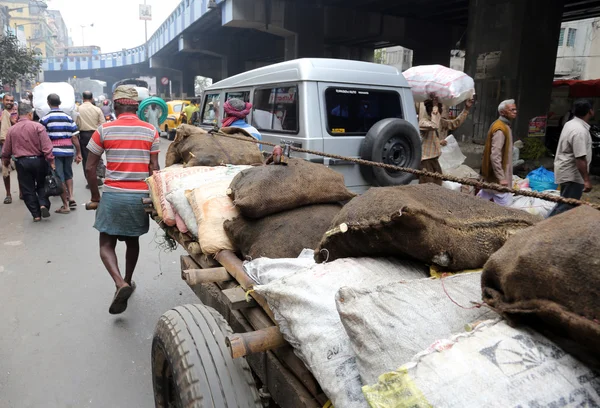 Hard working Indians pushing heavy load through streets in Kolkata