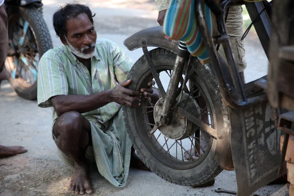 Mechanic repair the motorbike in Baidyapur, India.