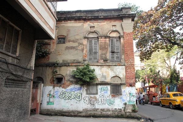 An aging, decaying, ex-colonial tenement block with shops in Kolkata, West Bengal, India