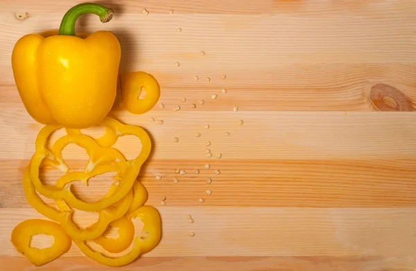Yellow sweet pepper on wooden background
