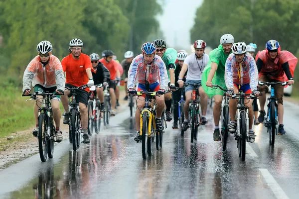 A group of cyclist racer racing  in the rain