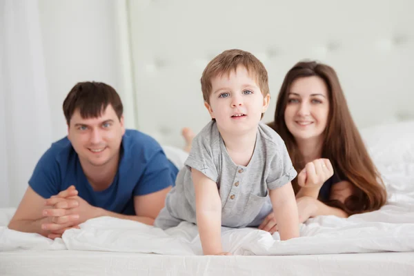 Little boy and parents On Parents Bed Wearing Pajamas