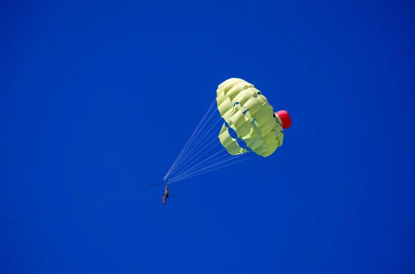 People on parachute in the blue sky