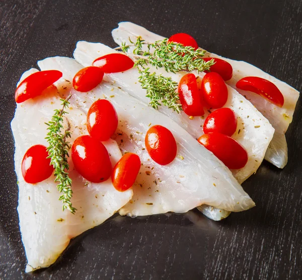 Raw sea bass fillets with tomatoes