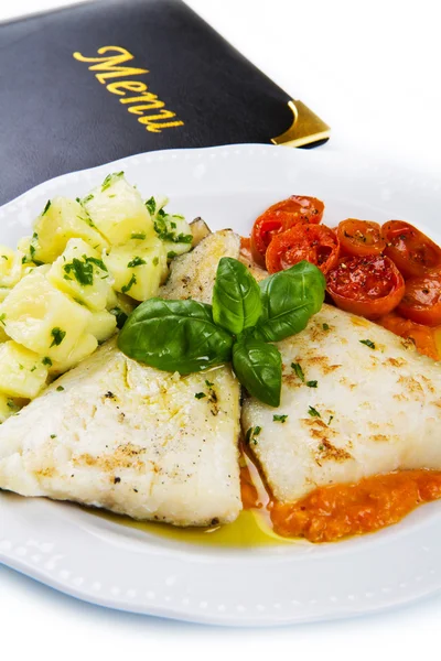 White dish of Fresh black cod with potatoes and tomatoes sauce