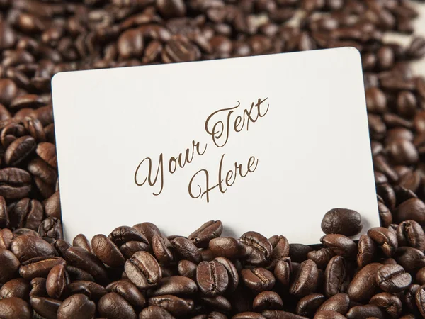 Blank white card  for your text  on coffee beans  background clo