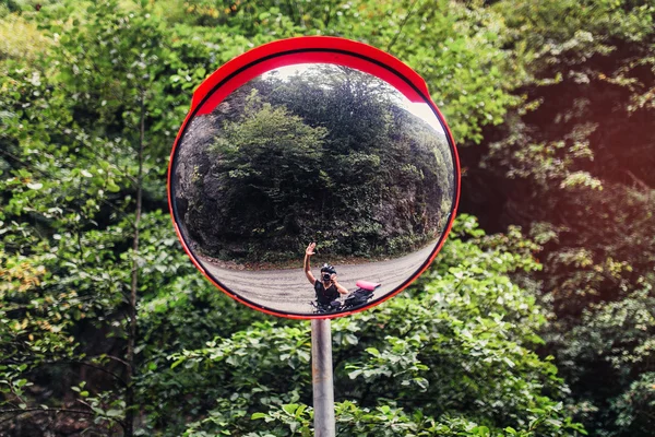 In road safety convex mirror reflecting Cycling biker. The concept of road safety for travelers, bicyclists and drivers of scooters
