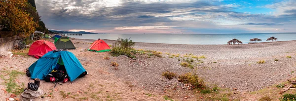 Camping with many tents on the beach at the seaside. Panorama Of Abkhazia, New Athos