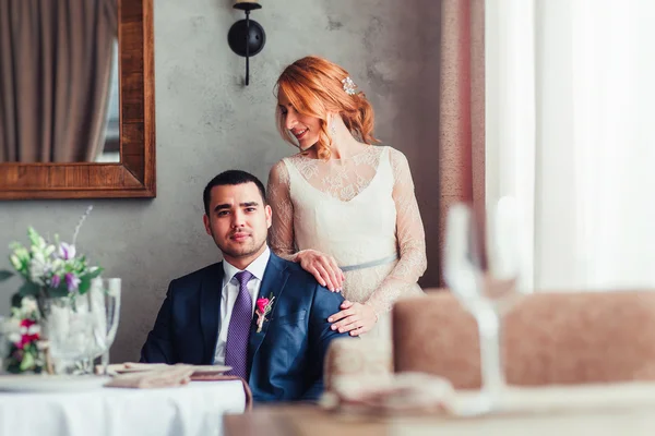 Romantic newlyweds posing in classic rustic restaurant room