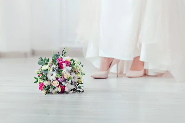 Wedding shoes and wedding bouquet of white roses