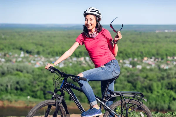Beautiful sport smiling girl sitting on her bike, summer time