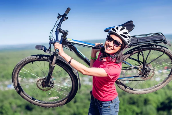 Young woman biker hold her bike up happy smiling outdoor. Cross