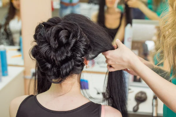 Closeup of hairdresser doing the styling for a festive evening o