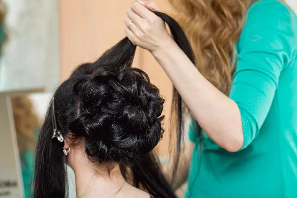 Closeup of hairdresser doing the styling for a festive evening o