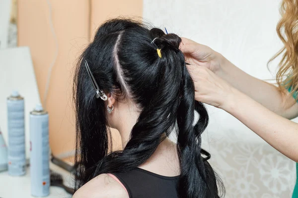 Evening hairstyle. brunette doing hairdresser and styling in barber salon
