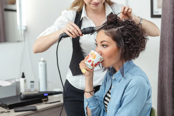 Cheerful woman in the Barber shop with beautiful unusual curly h