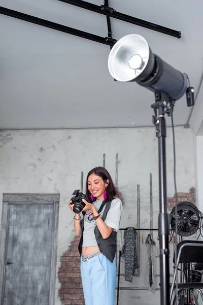 Photographer woman adjusts equipment flash, camera and softbox i