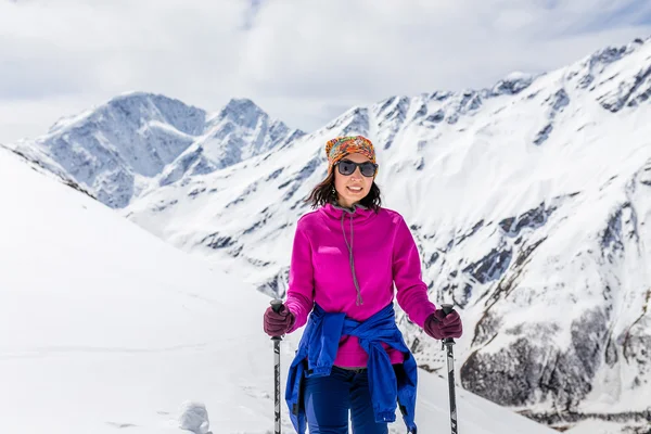 Woman hiker in bright clothes, nordic walking, healthy lifestyle in Himalaya Mountains in Nepal. Trekking and hiking on mountain peaks landscape.