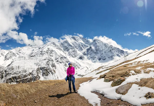 Tourists woman have a rest, Donguz-Orun 4468 m and Nakra Tau 4277 m peaks in Elbrus region, Caucasus, Russia