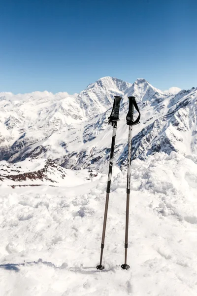 Skiing in mountains, close up of two ski poles sticks