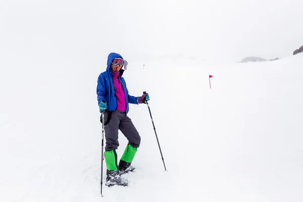 Mountain hiking group with trekking poles sticks having hard climbing trip in winter snow storm