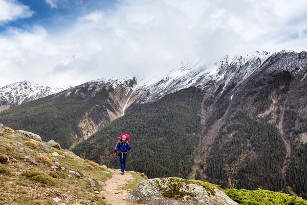 Woman mountain Hiker with backpack enjoy view in Caucasus mountains, Elbrus region, Russia.