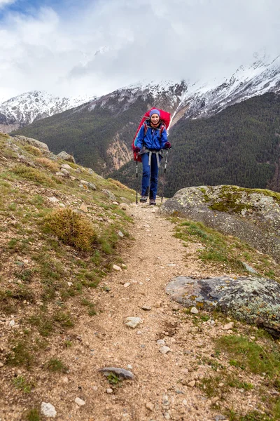 Woman mountain Hiker with backpack enjoy view in Caucasus mountains, Elbrus region, Russia.