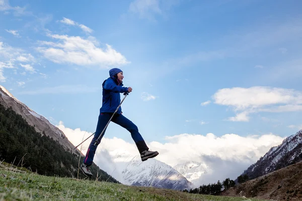 Woman jump through the gap between mountains of Caucasus
