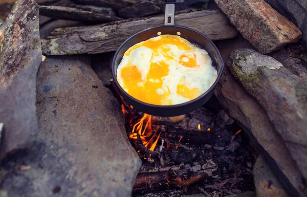 Eggs fried in a cast iron pan on the camping fire