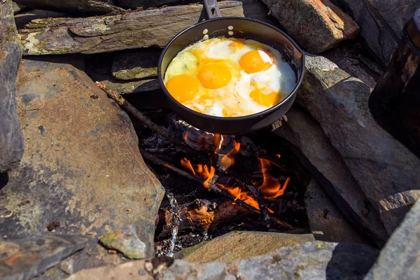 Eggs fried in a cast iron pan on the camping fire