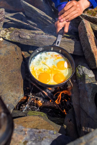Eggs fried in a cast iron pan on the camping fire