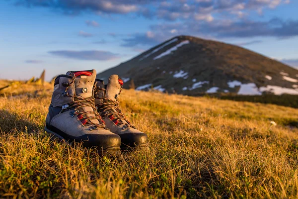 Hiking boots in the sun light in mountains